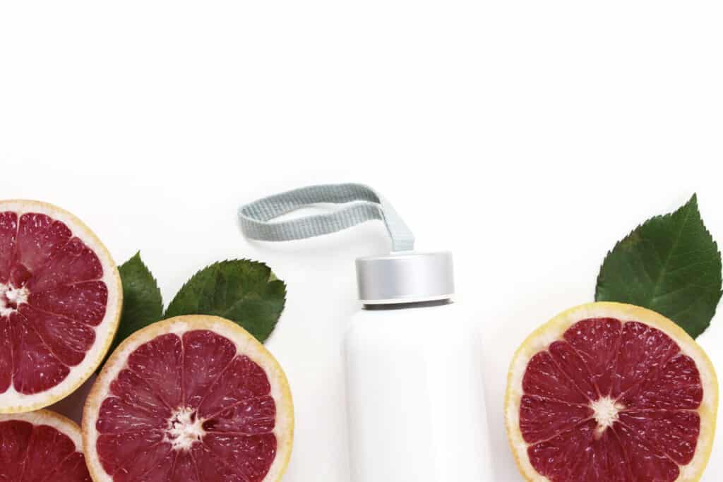 fruit infused water ideas with a water bottle and citrus on white background