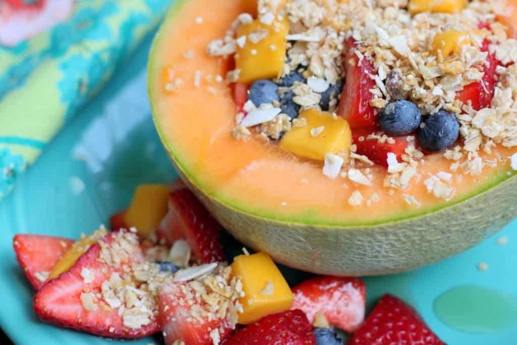 yogurt cantaloupe bowl recipe garnished with granola and fruit on a blue plate