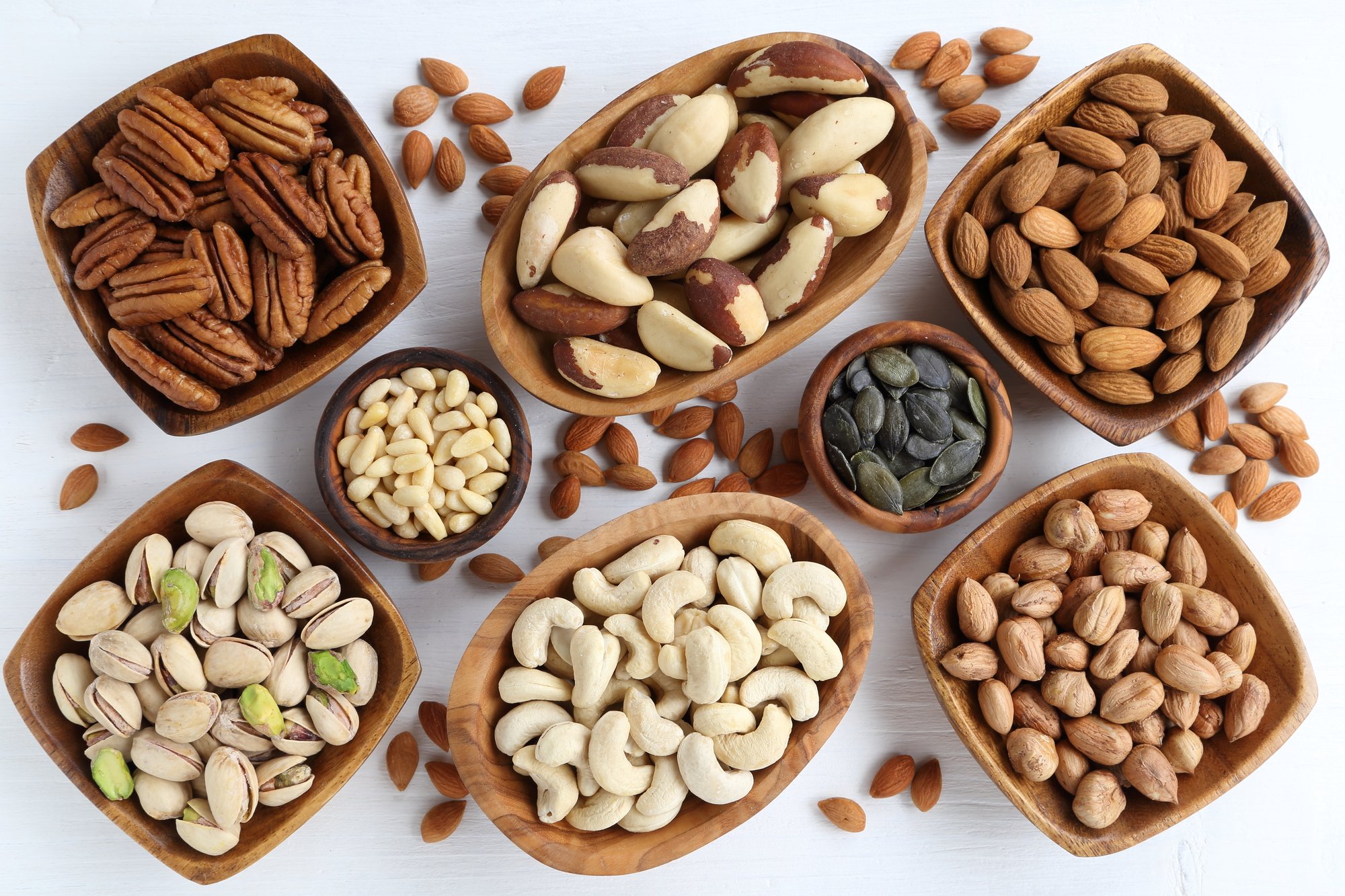 low carb nuts in wooden bowls on a white background