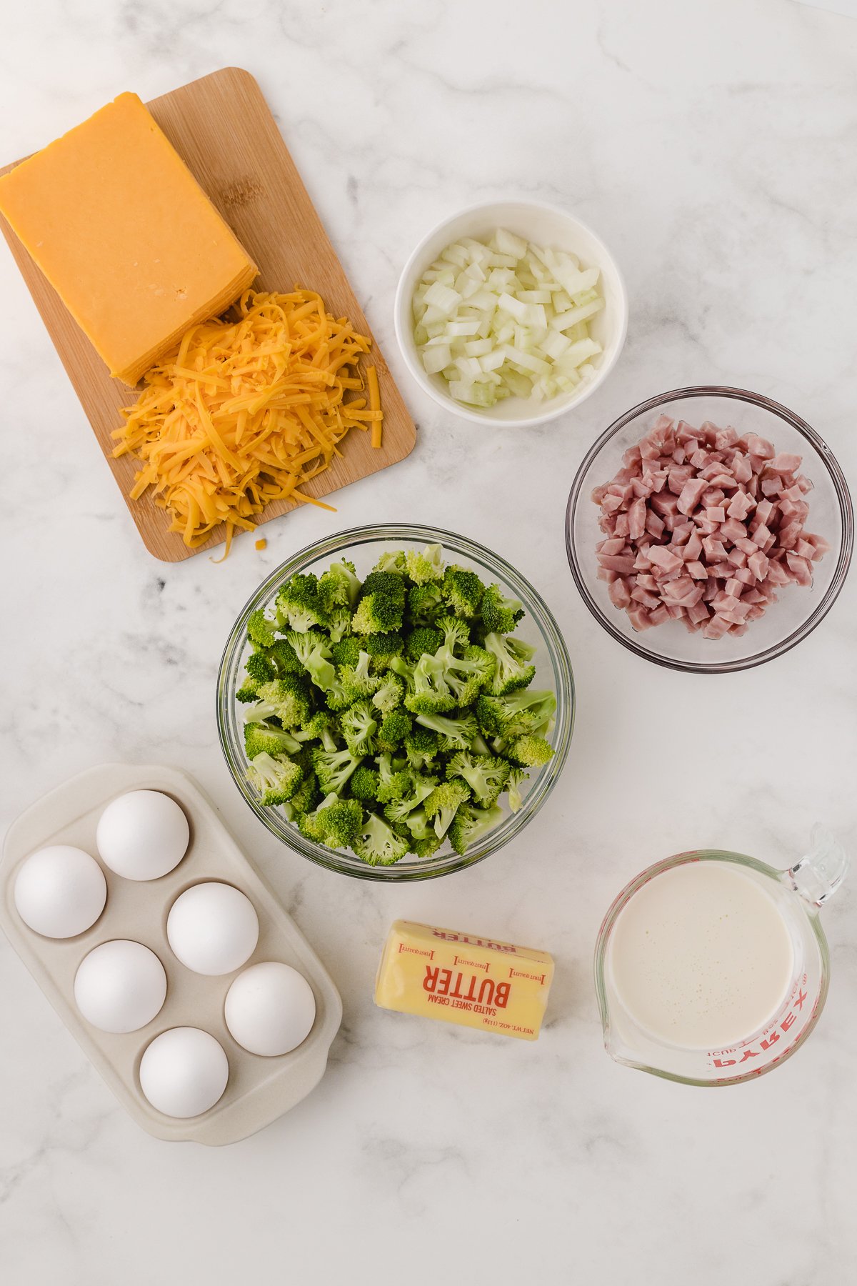 crustless quiche recipe ingredients on a white cutting board