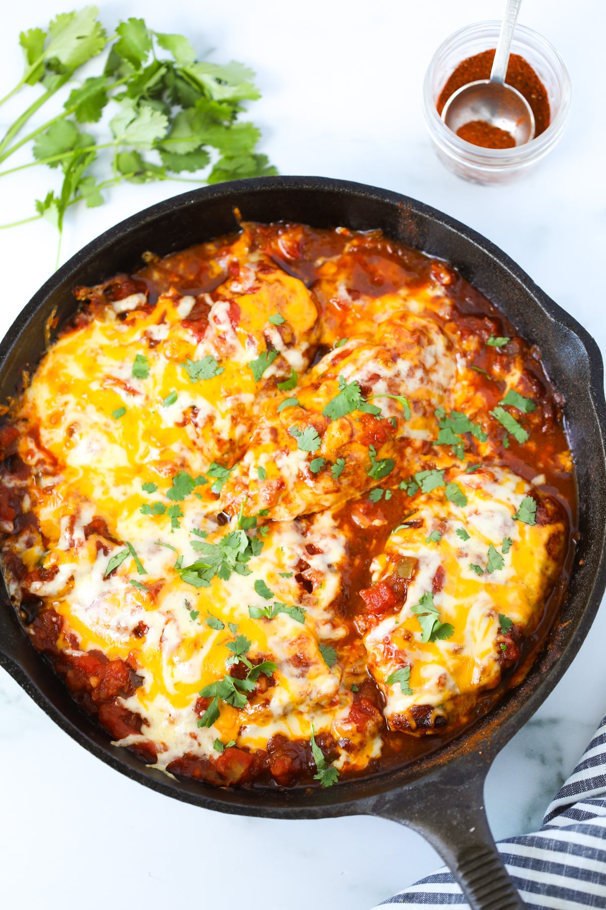 low carb salsa chicken bake in a cast iron skillet on a white background