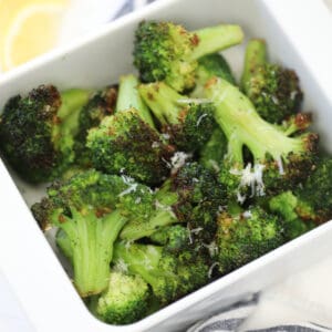 the frozen broccoli air fryer recipe in a white dish on a white background