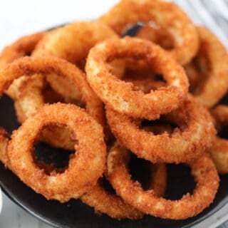 frozen onion rings air fryer recipe stacked up on a plate