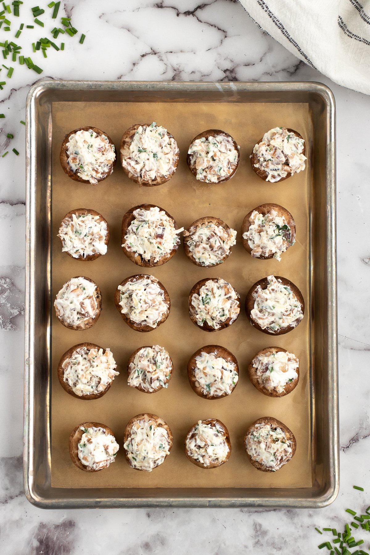 adding the bacon bits cream cheese filling to the mushrooms before baking in the oven