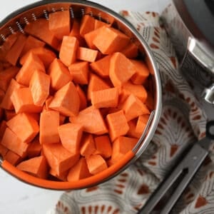 instant pot sweet potatoes cubed in a vegetable basket before cooking