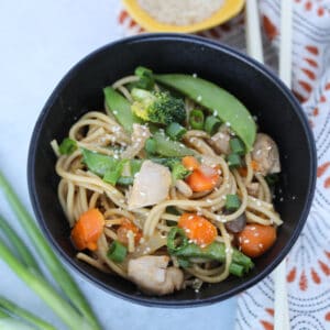 the chicken lo mein instant pot recipe with chopsticks on a white background