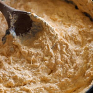 low carb buffalo chicken dip getting stirred in a pan