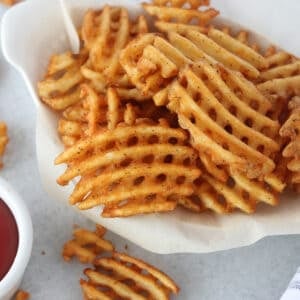 alexia air fryer frozen waffle fries in a white basket ready to eat