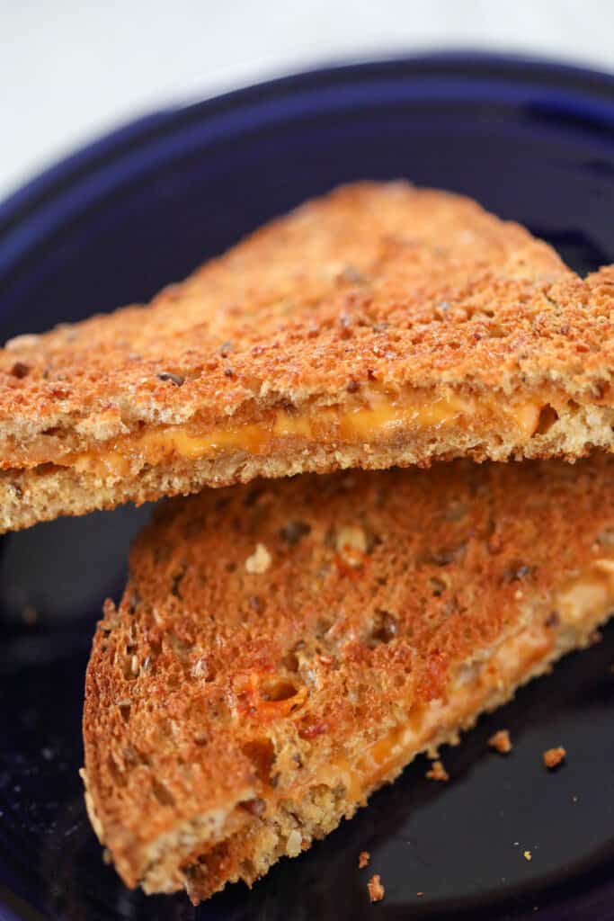 the grilled cheese in air fryer recipe on a blue plate after cooking