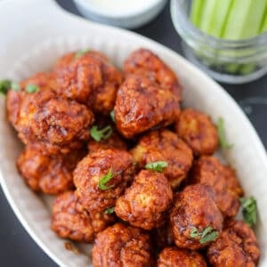air fryer boneless chicken wings chicken bites from frozen with buffalo hot sauce in a white dish