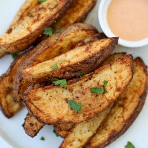 homemade potato wedges air fryer recipe on a white plate with dipping sauce