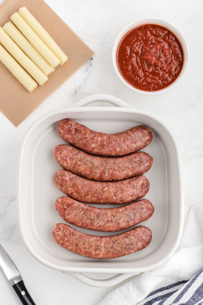 stuffed sausage with cheese ingredients on a cutting board before cooking