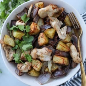 air fryer chicken and potatoes stirred and ready to eat in a bowl with a fork