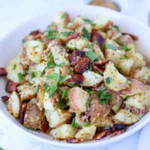 german potato salad in instant pot while bowl with bacon and green onions