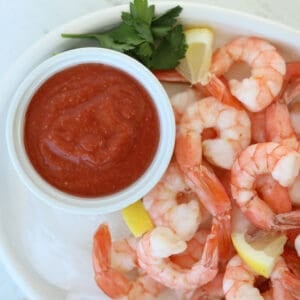 low carb cocktail sauce on a white plate with cooked shrimp