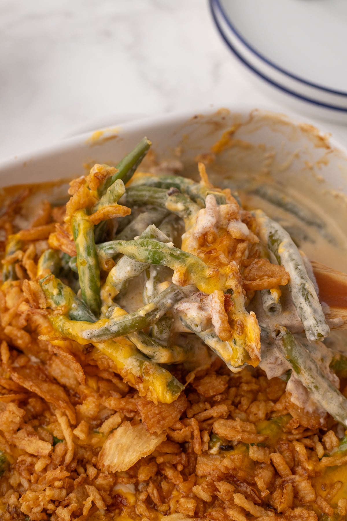 green bean casserole with a cream cheese sauce scooped on a spoon after cooking