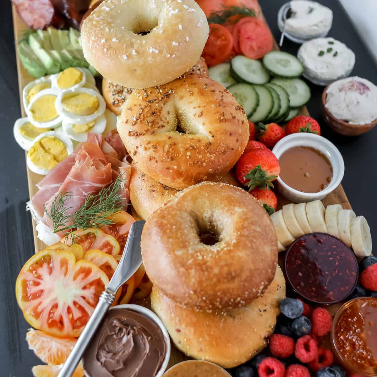 bagel charcuterie board ideas piled up on a wooden cutting board