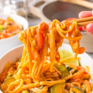 curry rice noodles on chopsticks with Thai flavors and red curry paste
