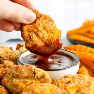 chicken nuggets dipped in bbq sauce.