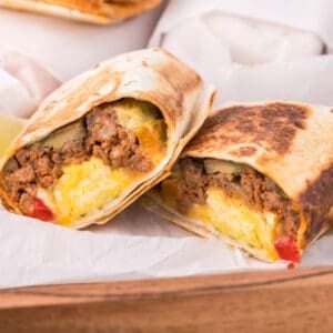 make ahead breakfast burritos cut in half showing the filling inside.