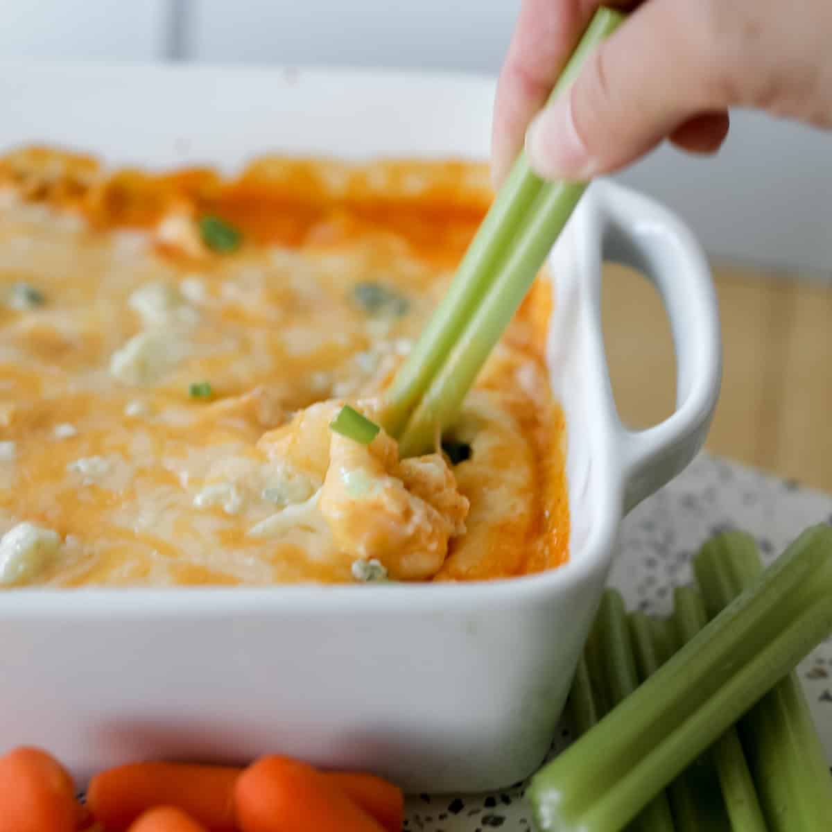 cottage cheese buffalo chicken dip with celery being used as a dipper