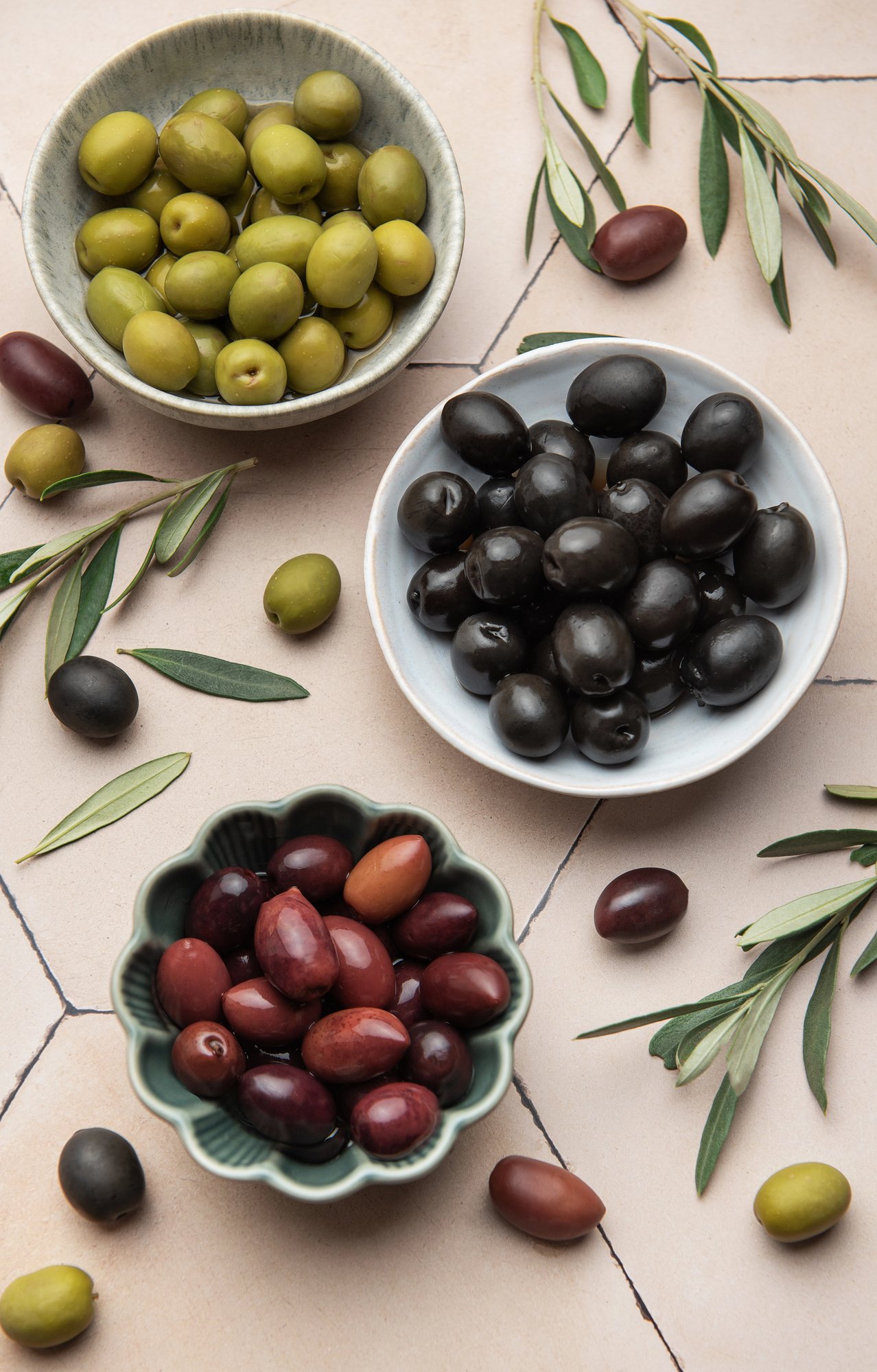 olives in small bowls on a light pink background