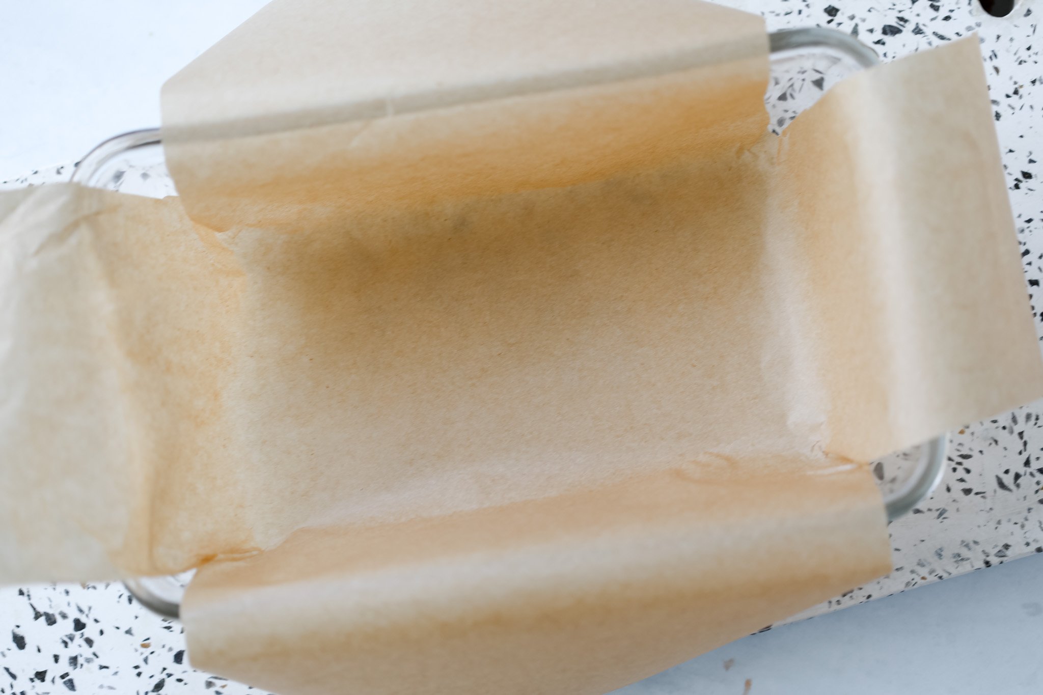 layering parchment paper in a loaf pan for cottage cheese fudge