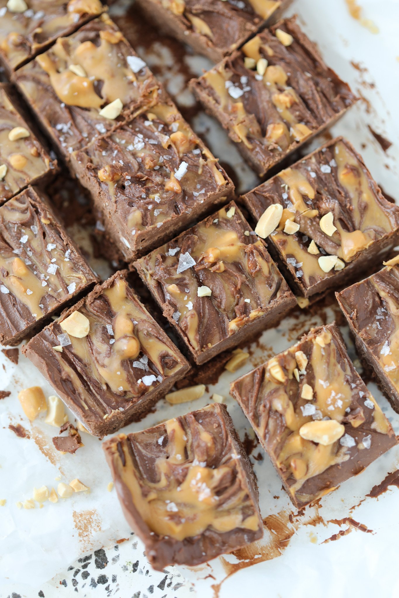 cottage cheese fudge squares on a cutting board sprinkled with peanuts and peanut butter