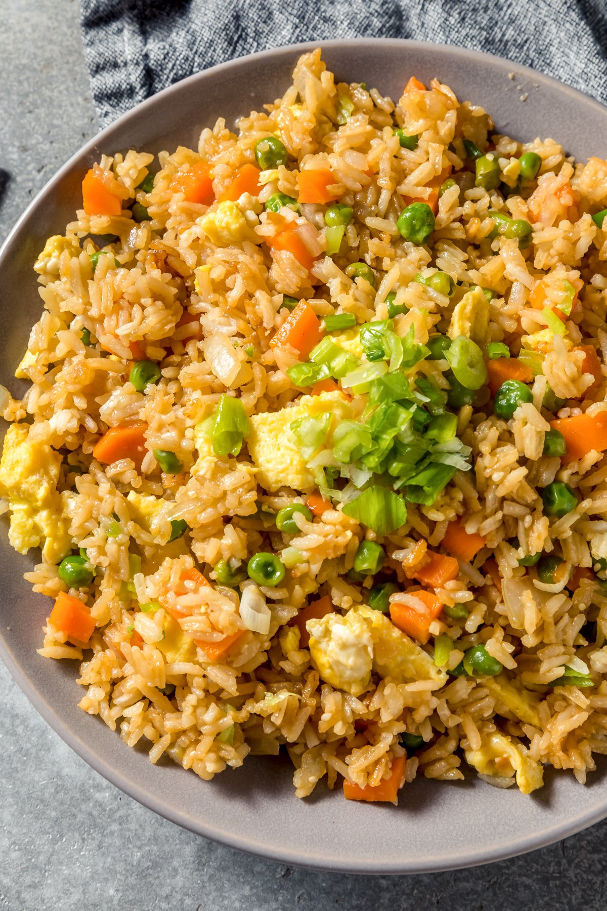 blackstone chicken fried rice with frozen vegetables in a gray serving dish after cooking on a flat top griddle