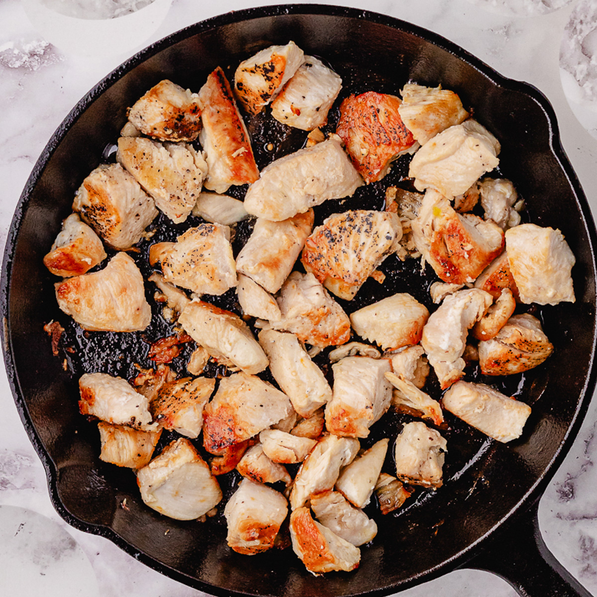 pan frying the cubed chicken in a skillet