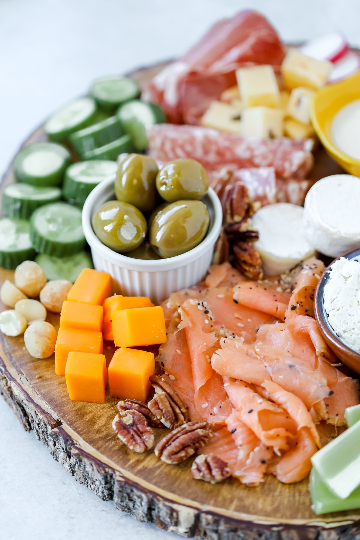 low carb charcuterie board featuring salmon cheese olives brie cucumbers and other no carb foods