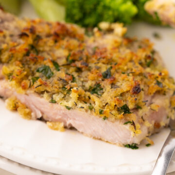 air fryer bone in breaded pork chops that are thin cut on a white plate with broccoli