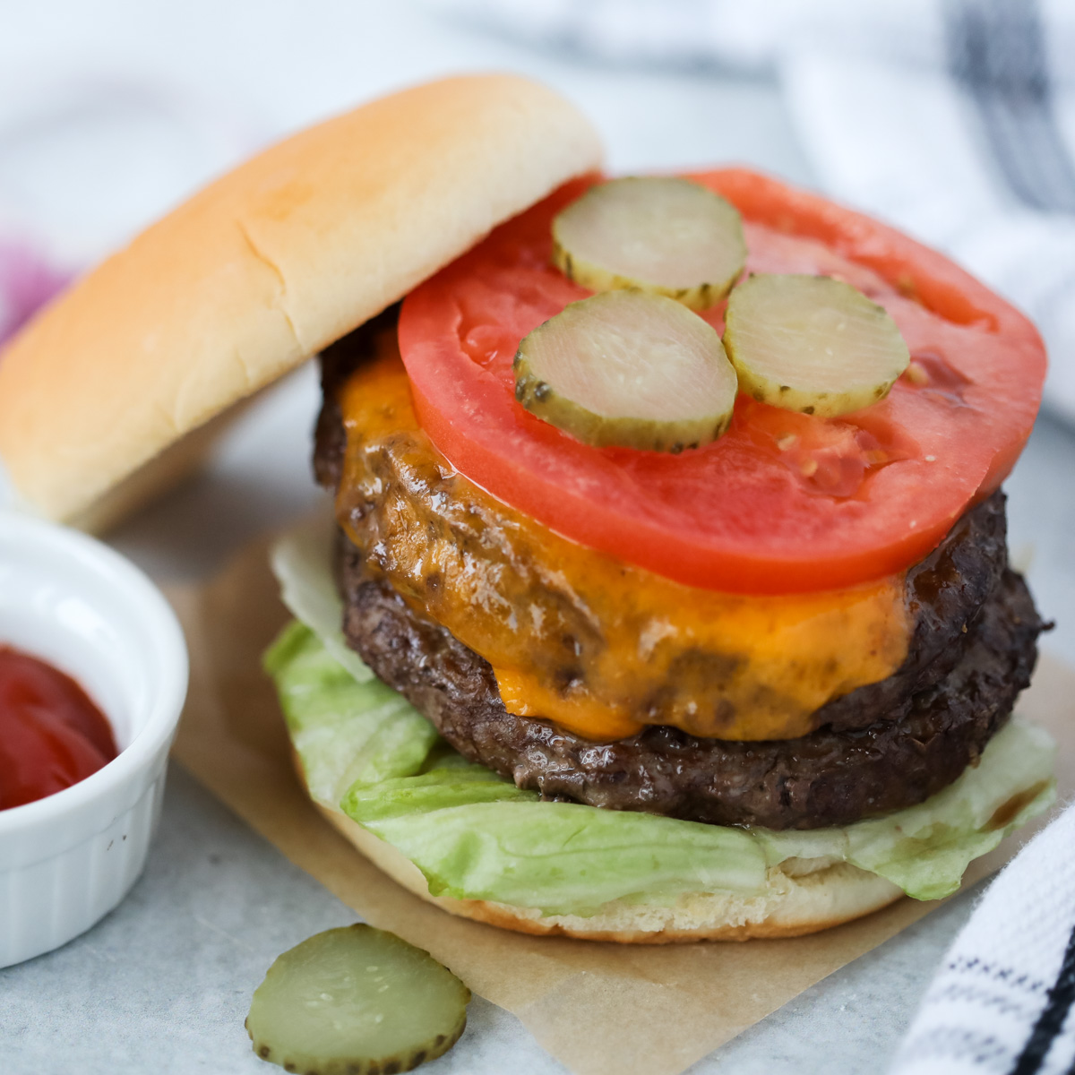 air fryer hamburgers stacked on a bun with the top on the side