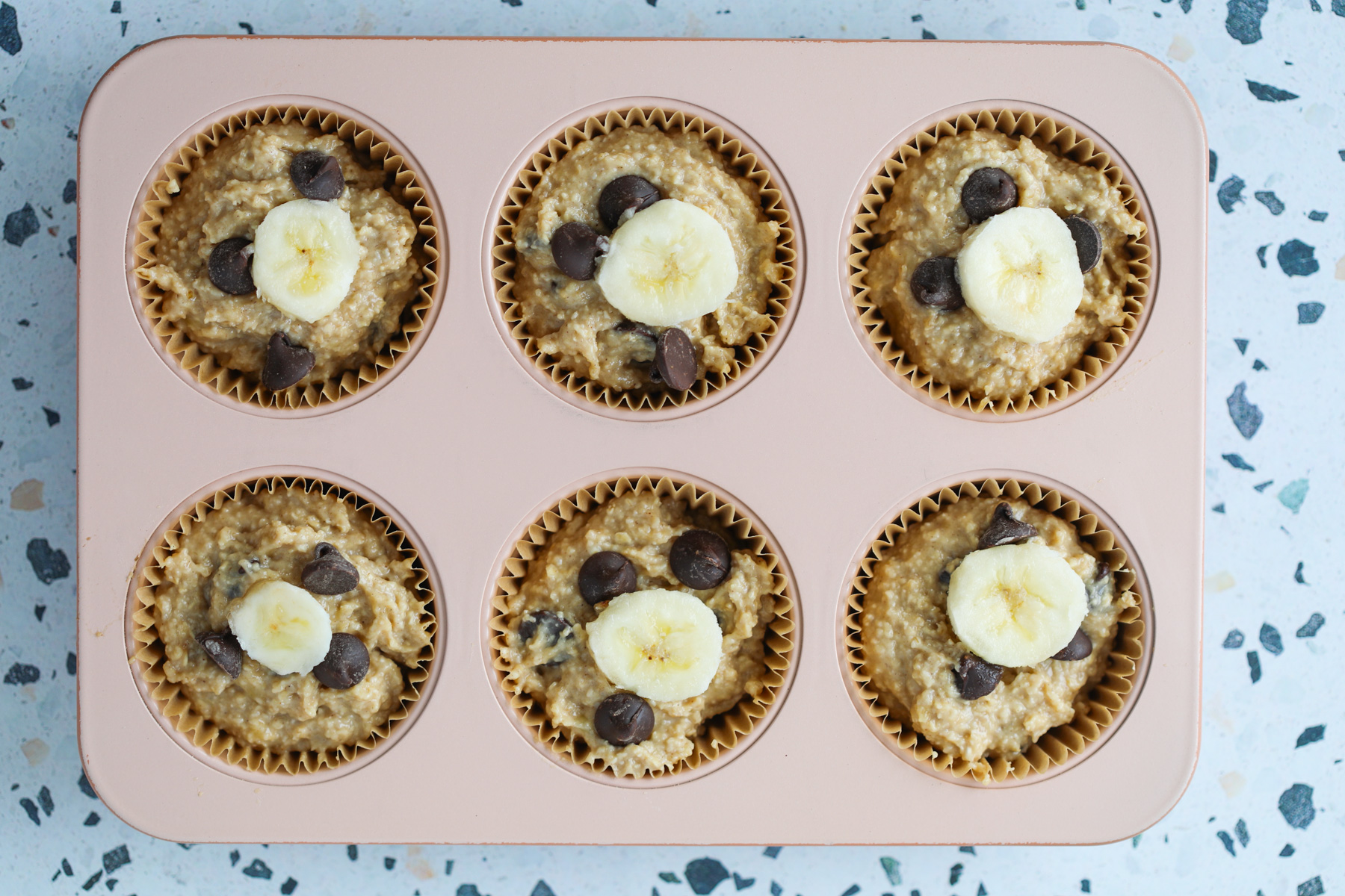 adding the protein banana batter with protein powder to the muffin tin