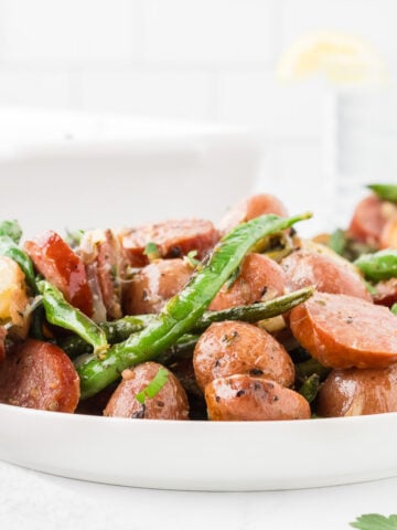 crockpot swamp potatoes recipe close up image with sliced smoked sausage fresh green. beans and red potatoes
