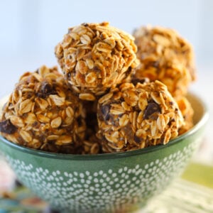 healthy pumpkin protein balls with rolled oats and protein powder stacked up in a green bowl