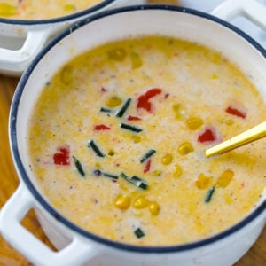 Creamy corn chowder topped with red bell pepper and fresh chives as garnish