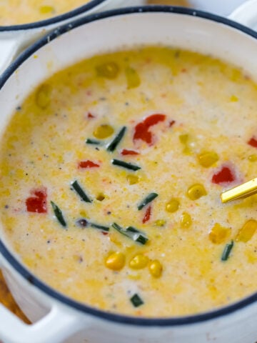 Creamy corn chowder topped with red bell pepper and fresh chives as garnish