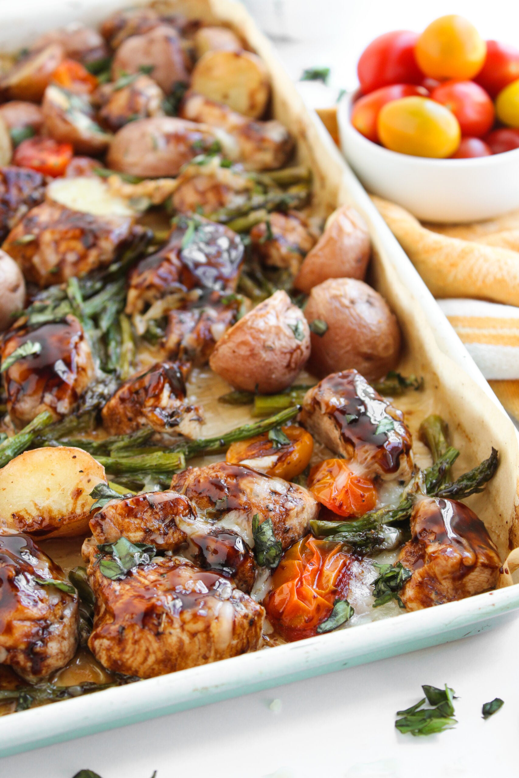 Balsamic chicken and veggies spread out on sheet pan.