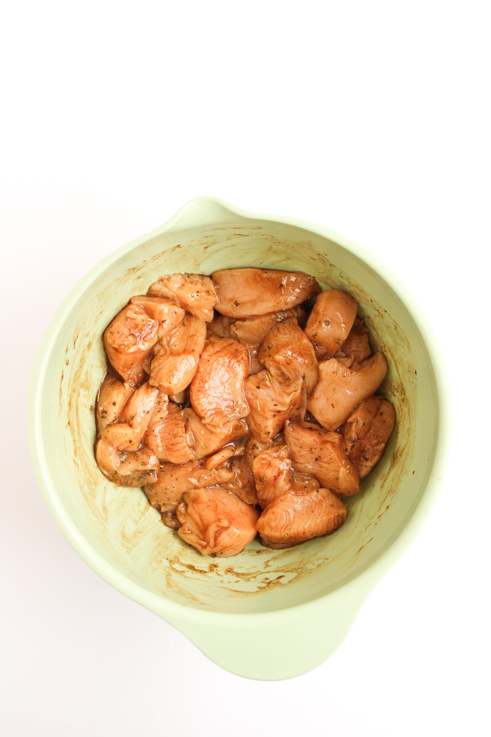 Bowl of cubed chicken being marinated.