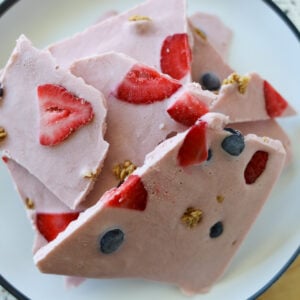 Pieces of strawberry frozen yogurt bark on a plate.