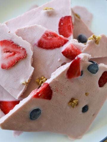 Pieces of strawberry frozen yogurt bark on a plate.