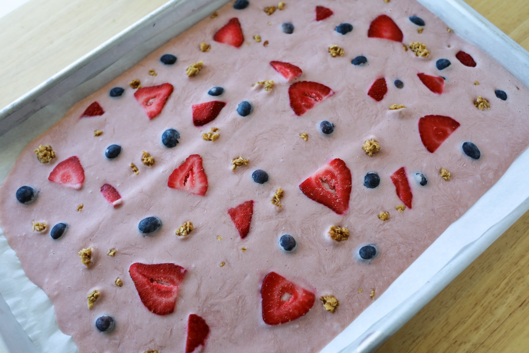 frozen yogurt bark on a baking sheet after being frozen