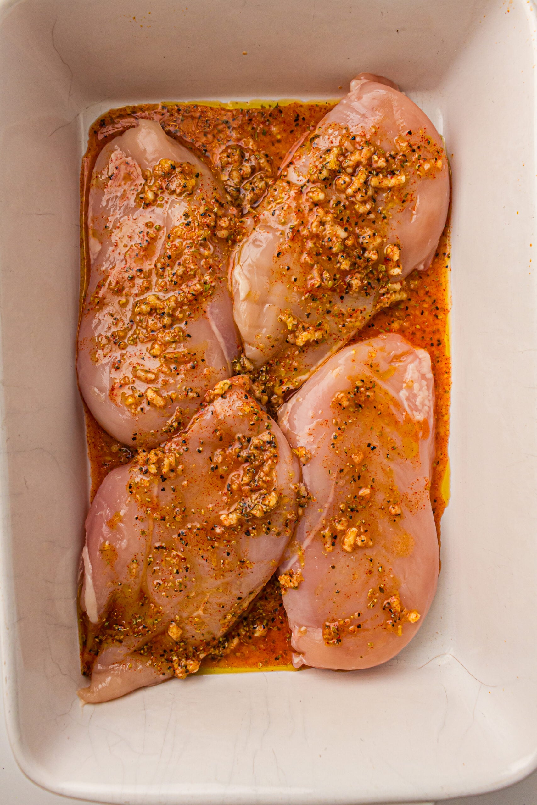 Chicken breasts seasoned and ready to be baked.